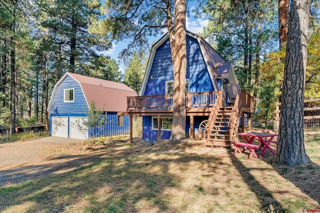 back of house with a wooden deck and a garage