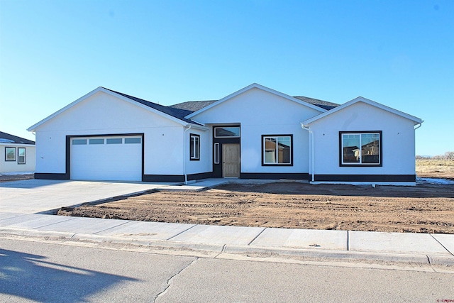 ranch-style house with a garage, concrete driveway, and stucco siding