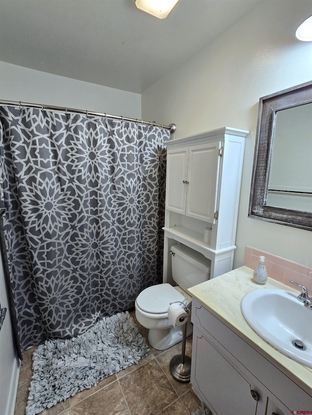 bathroom with tile patterned flooring, vanity, toilet, and walk in shower