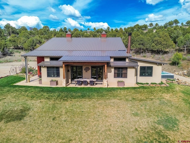 back of house featuring a lawn and a patio