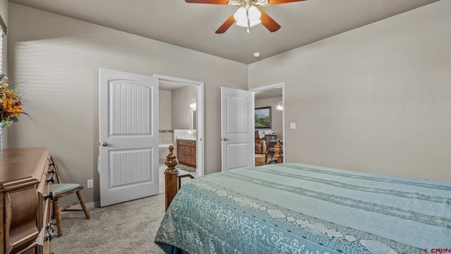 bedroom with ceiling fan, ensuite bathroom, and light carpet