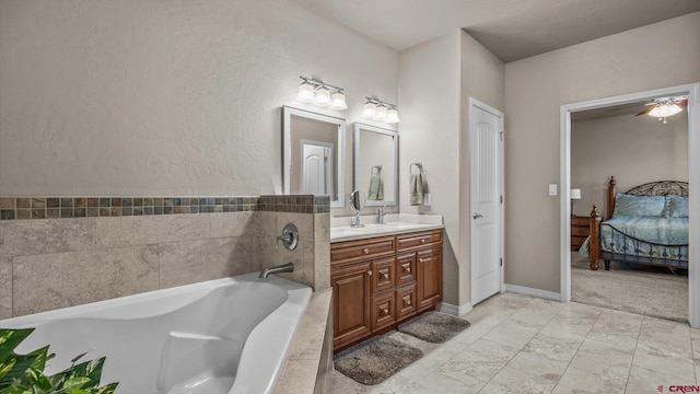 bathroom featuring vanity, ceiling fan, and a tub to relax in