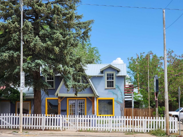 318 E Main St, Cortez, CO 81321 - view of front of house featuring stucco siding, a metal roof, french doors, and a fenced front yard
