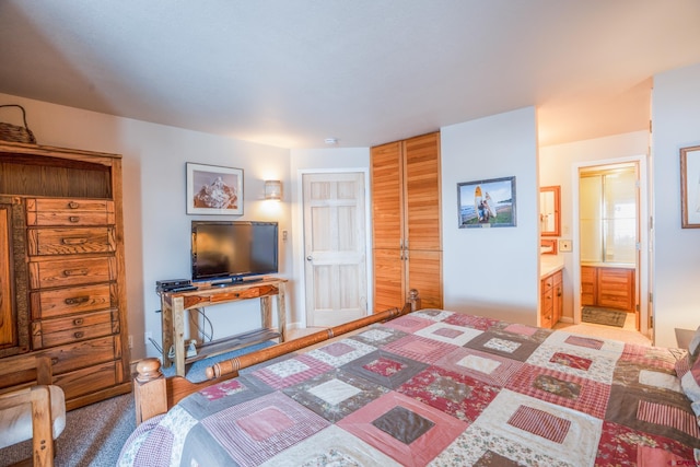 carpeted bedroom with ensuite bath and a closet