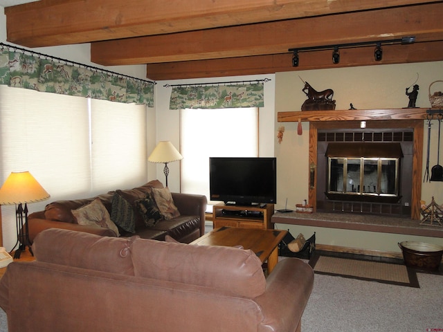 living room featuring a fireplace, beam ceiling, carpet floors, and track lighting