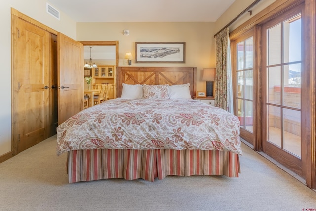 carpeted bedroom featuring an inviting chandelier