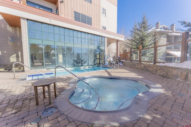 view of swimming pool with a patio area and a hot tub