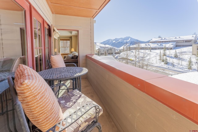 snow covered back of property with a mountain view