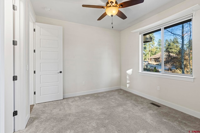 carpeted spare room featuring ceiling fan