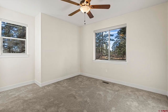 carpeted spare room featuring ceiling fan