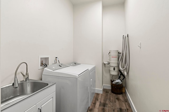 laundry room featuring sink, cabinets, dark wood-type flooring, and washing machine and clothes dryer