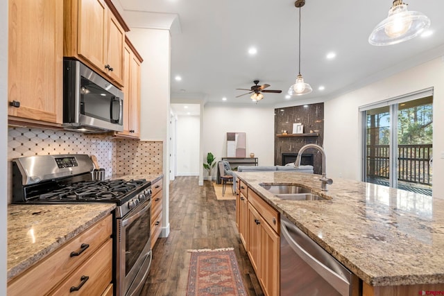 kitchen featuring a kitchen island with sink, sink, hanging light fixtures, dark hardwood / wood-style flooring, and stainless steel appliances