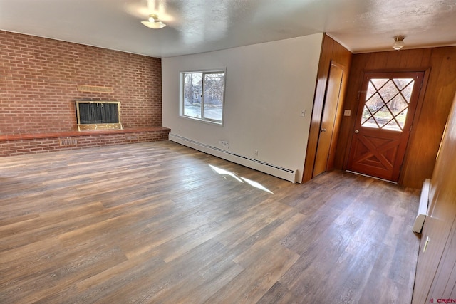 foyer entrance with a wealth of natural light, a baseboard radiator, and hardwood / wood-style flooring