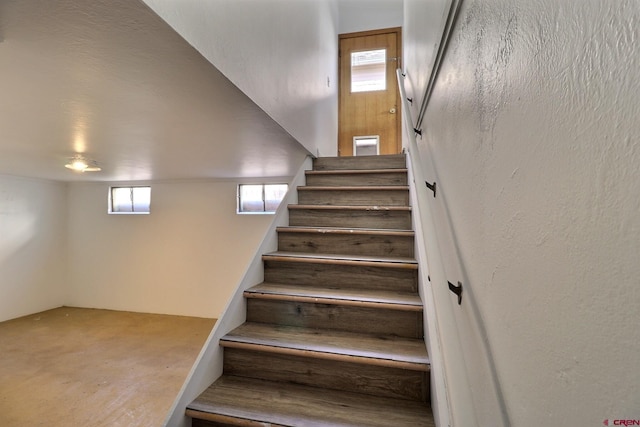 staircase featuring concrete flooring