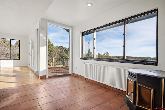 unfurnished sunroom featuring radiator heating unit