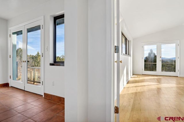 doorway to outside with a wealth of natural light, french doors, hardwood / wood-style floors, and lofted ceiling