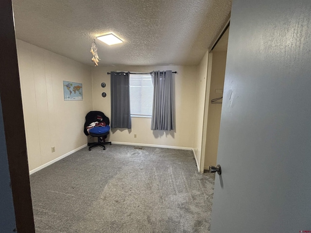 unfurnished room featuring carpet and a textured ceiling