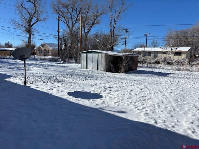 snowy yard with a shed