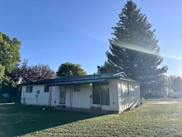 back of property featuring a lawn