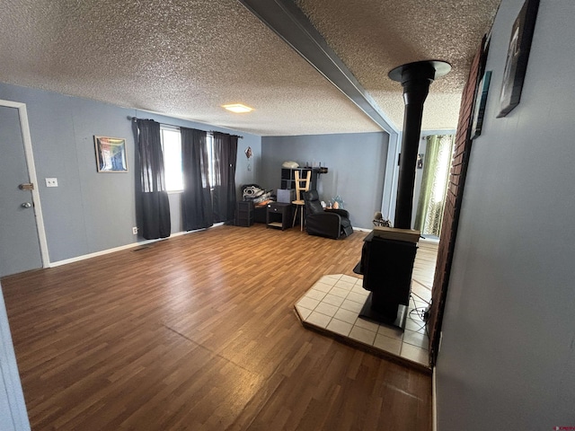 interior space featuring hardwood / wood-style flooring, beam ceiling, and a textured ceiling