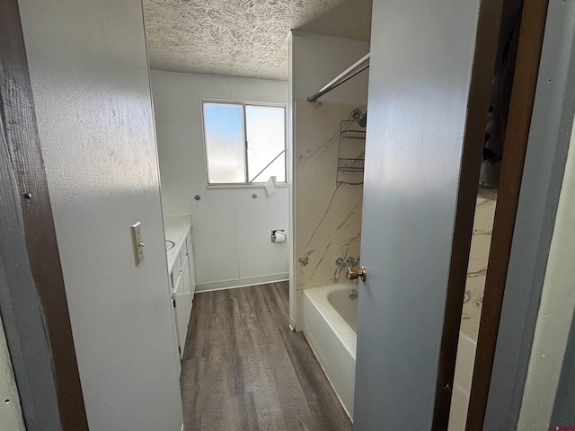 bathroom with vanity, shower / tub combination, a textured ceiling, and hardwood / wood-style flooring