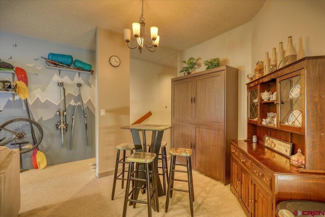 carpeted dining space featuring a chandelier and a textured ceiling