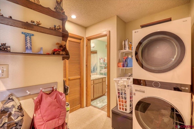 laundry room with stacked washer / dryer, light colored carpet, and a textured ceiling