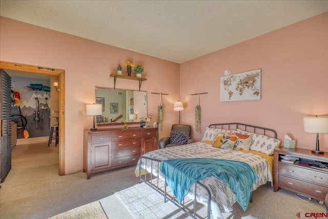 bedroom with light colored carpet and a textured ceiling