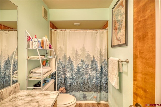 bathroom featuring wood-type flooring, vanity, and toilet