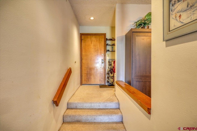 staircase with a textured ceiling