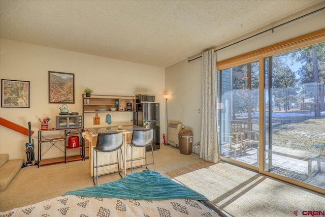 carpeted bedroom with access to outside, stainless steel refrigerator, and a textured ceiling