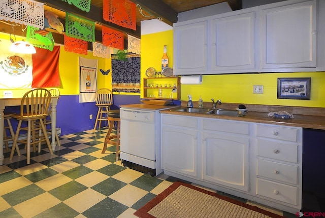 kitchen with dishwasher, beam ceiling, white cabinetry, and sink