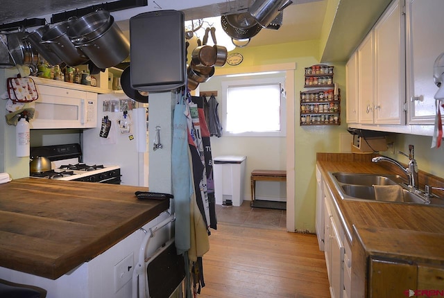 kitchen with wooden counters, white appliances, sink, light hardwood / wood-style flooring, and white cabinetry