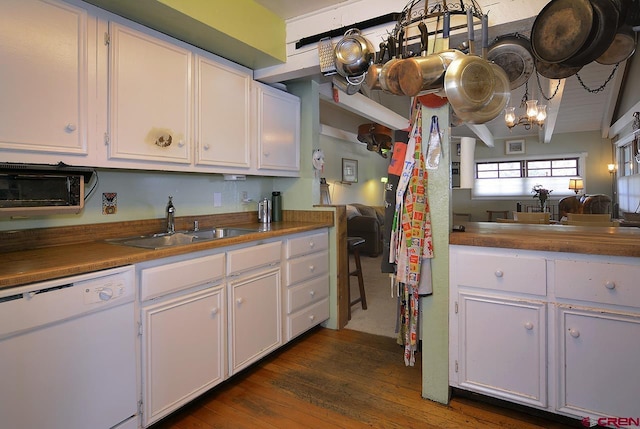 kitchen with dishwasher, lofted ceiling, dark wood-type flooring, sink, and white cabinetry