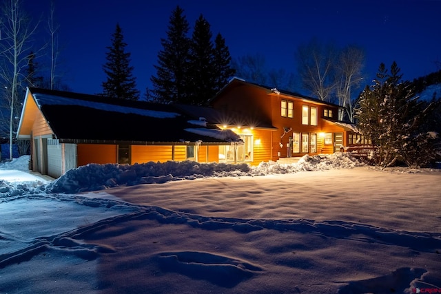 snow covered property with a garage