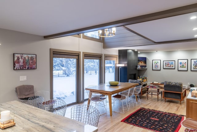 dining area featuring light hardwood / wood-style flooring, beamed ceiling, and a chandelier