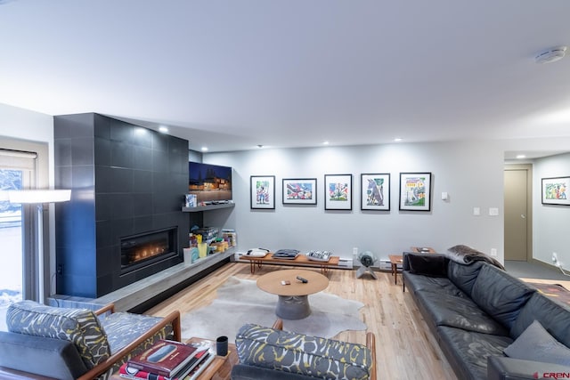 living room with light hardwood / wood-style floors and a tile fireplace