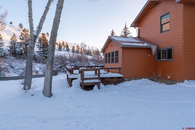 yard layered in snow featuring a deck