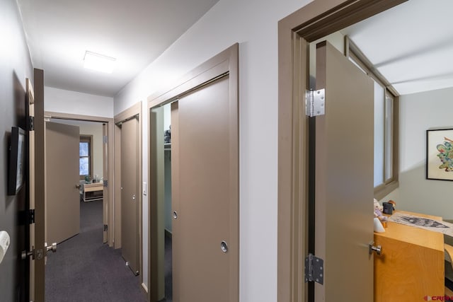 corridor featuring dark colored carpet