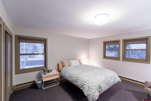 bedroom with baseboard heating, multiple windows, and carpet floors