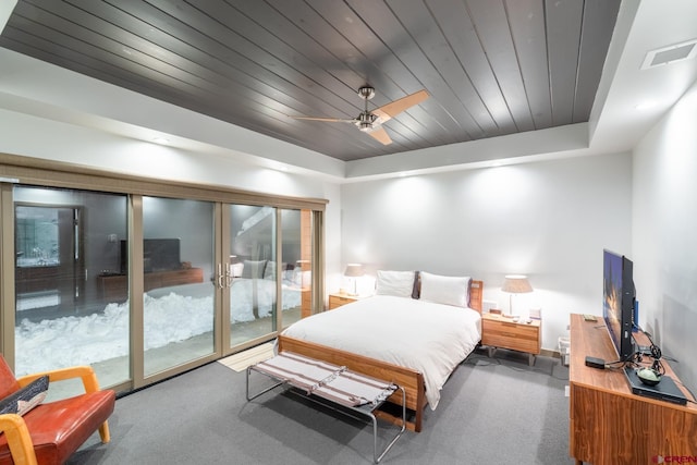 carpeted bedroom with access to exterior, a tray ceiling, ceiling fan, and wood ceiling