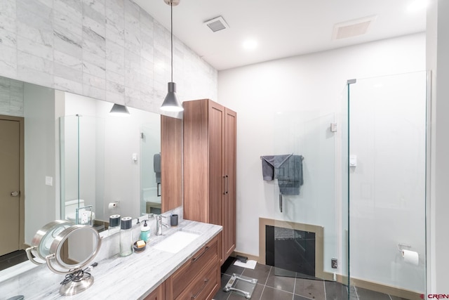 bathroom with tile patterned floors, vanity, and a shower with door