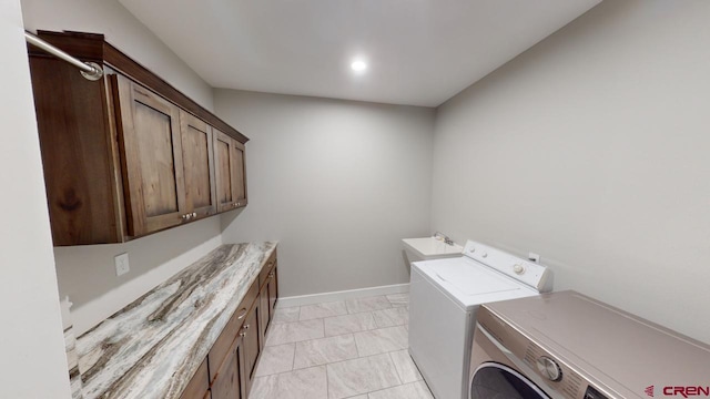 laundry area with cabinets, separate washer and dryer, light tile patterned flooring, and sink