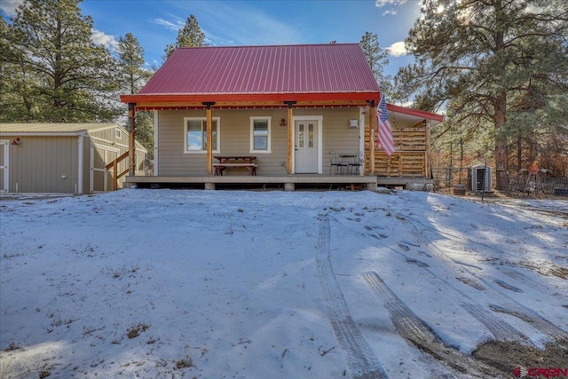 view of front of home featuring covered porch and a storage shed