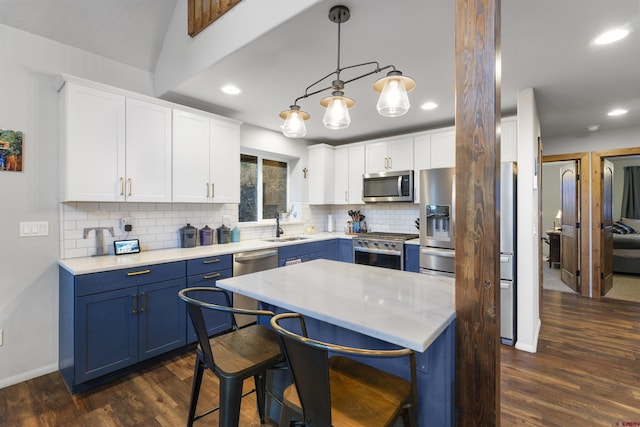 kitchen with appliances with stainless steel finishes, white cabinetry, blue cabinets, and dark hardwood / wood-style floors