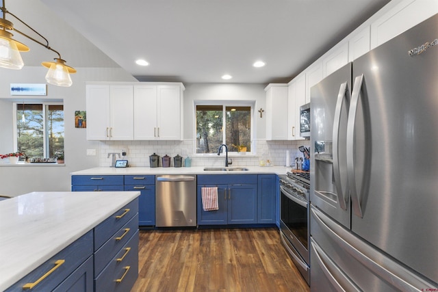 kitchen with white cabinets, decorative light fixtures, stainless steel appliances, and sink