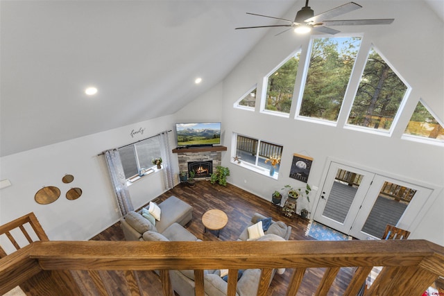 living room with a fireplace, hardwood / wood-style floors, high vaulted ceiling, and ceiling fan