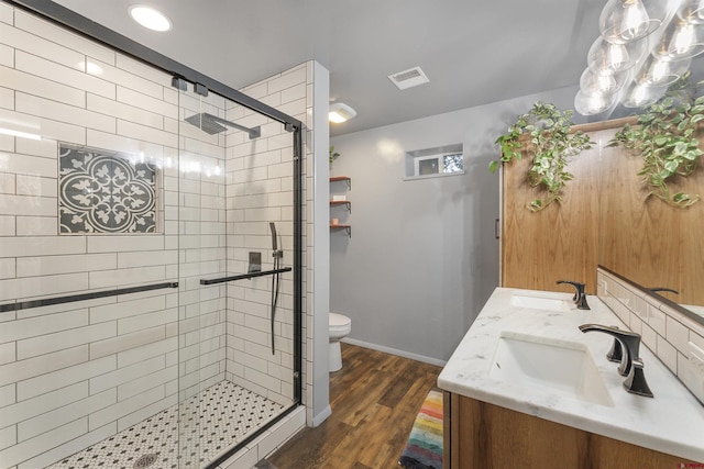 bathroom with hardwood / wood-style floors, vanity, toilet, and walk in shower