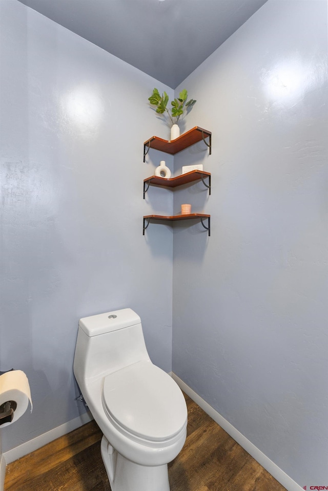 bathroom featuring wood-type flooring and toilet