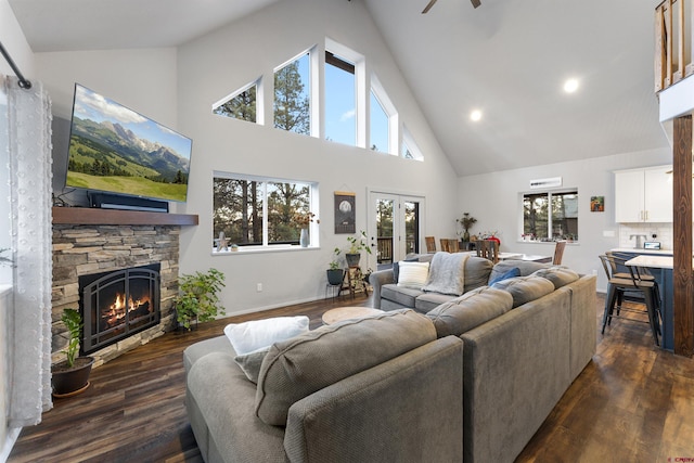 living room featuring dark hardwood / wood-style floors, a healthy amount of sunlight, a fireplace, and high vaulted ceiling